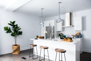 kitchen with white walls and brown stools against a white kitchen island