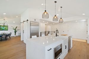 kitchen with brown wood floors and metal pendant lights over kitchen island